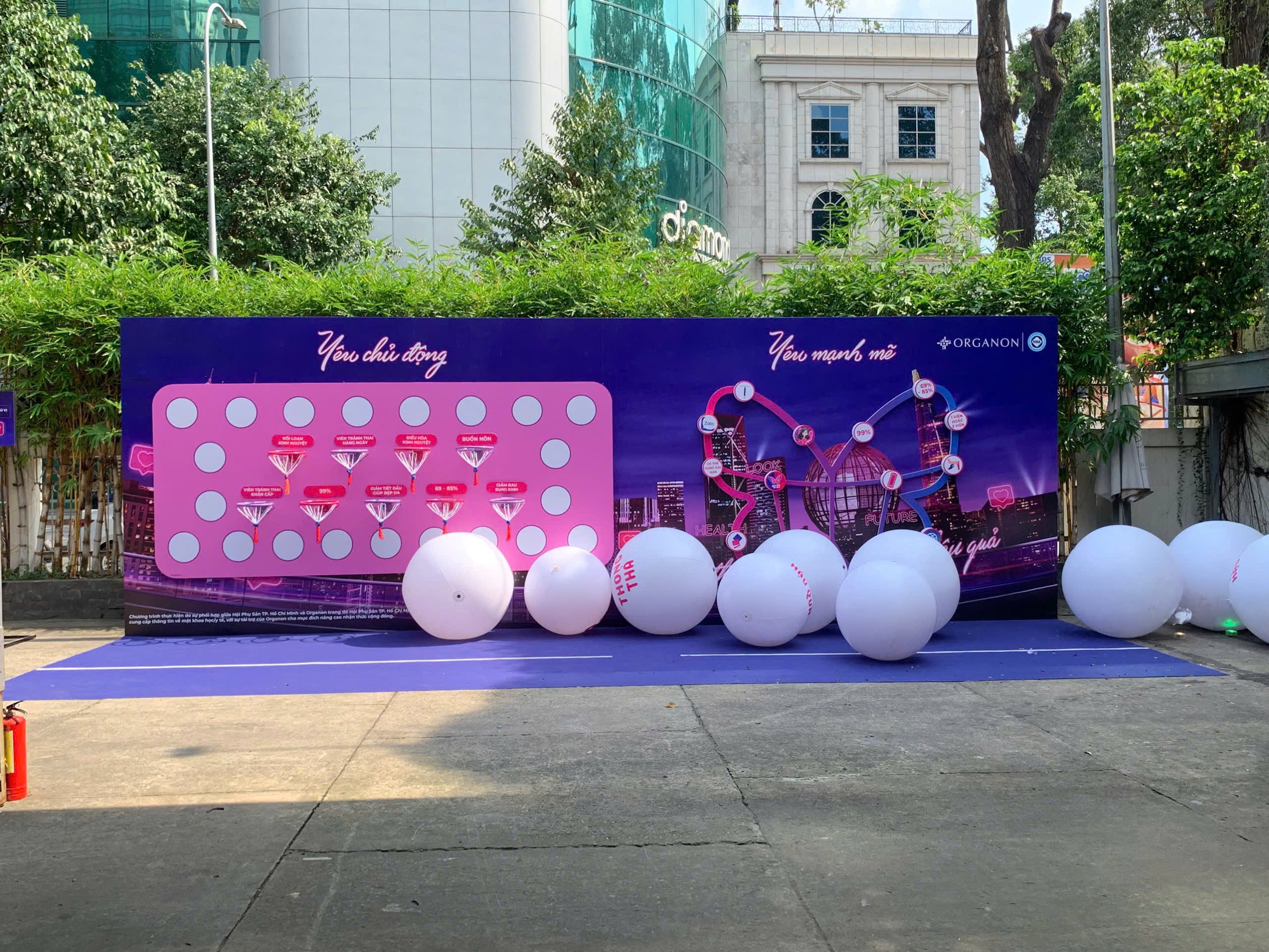 Purple and pink branded game installation with oversized white spheres